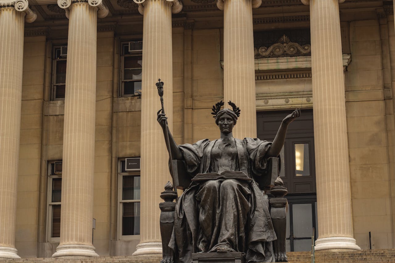 Bronze statue at Low Memorial Library, NYC, showcasing neoclassical architecture.